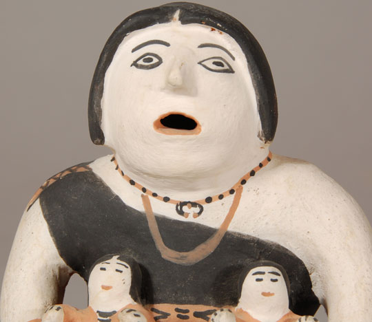 It is well known that Helen Cordero made what has now been named the Storyteller figurine in 1964.  Her definition of a storyteller was that it was in honor of her grandfather, a well-known storyteller at Cochiti Pueblo, so it was always a male figurine in her eyes. Before Cordero's first storyteller, female figurines were made by potters at Cochiti and they have been named Singing Mothers or Singing Ladies.  In the book The Pueblo Storyteller by Barbara Babcock, there is a Singing Mother figurine which Babcock says pre-dates 1930.  She further states that "The shape of her head and ears and her 'coffee bean' eyes are remarkably similar to figures made by Felipa Trujillo in the 1960s and 1970s."  If this is indeed one made by Felipa Trujillo before 1930, she must be one of the earliest Cochiti potters to do so. Babcock also states that Trujillo began making storyteller figurines in the mid-1960s.  We know that Cordero made the first one in 1964, so Trujillo must not have been far behind her.  Trujillo was one of the seven artists represented in the Museum of International Folk Art exhibit "What is Folk Art?" in 1973.  It seems fairly obvious that Trujillo was one of the earliest potters to make storyteller figurines. This storyteller is signed Cochiti NM Felipa on the underside.  There are two children sitting on the adult&rsquo;s lap and she has her hands holding on to them.  It is believed that this figurine was made in the 1970s. Condition:  Structurally the storyteller figurine is in excellent condition.  There are some minor scratches on the black dress but nothing of great significance. Provenance: from a Santa Fe gentleman Recommended Reading: The Pueblo Storyteller by Barbara Babcock 