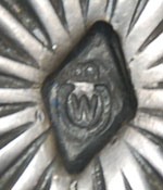 The buckle is stamped with a capital letter W or M within what appears to be a horseshoe symbol with the letter B on its side.  