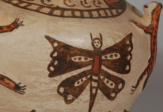 During the time that Indian Trader C. G. Wallace was active at Zuni Pueblo, in the 1920s and later, Zuni potters responded to the increased demand for pottery.  The 1920s was a revival period for pottery after a lapse of a couple decades of less interest.  This jar is typical of the enthusiasm potters had to provide pottery that would appeal to collectors, tourists and museums.  The more decoration, the better!  Appliqué frogs near the neck of the vessel and plumed serpents around the neck were traditional design elements on both ceremonial and secular jars, but the addition of butterflies and tadpoles was an attempt to appeal to a sophisticated market, and it did.  Jars such as this one were very popular with collectors and museums.  Condition:  very good condition with professional repairs having been made to two of the frog heads, and a slip crack on the bottom of the jar.  Provenance: from the Katherine H. Rust collection  Recommended Reading:  The Pottery of Zuni Pueblo by Francis Harlow and Dwight Lanmon 