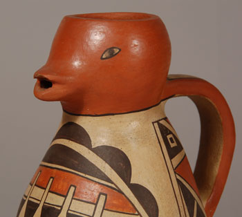 Pueblo potters responded well to the curio trade market after World War II when American tourists hit the road again and travelled throughout the Southwest.  The Grand Canyon of Arizona and the pueblo villages of New Mexico were favored.  Candlesticks, sugar and creamer sets, pitchers, picture frames and a variety of other items that would qualify as tourist collectibles were made in abundance.  This pitcher, in the shape of a duck, is typical of what a tourist would find and take home as a souvenir.  There is no potter’s name affixed to it so the creator will remain unknown.  Condition: there is a small chip under the upper lip of the duck but it is not readily noticeable  Provenance: from the collection of Katherine H. Rust  Recommended Reading: Collections of Southwestern Pottery: Candlesticks to Canteens, Frogs to Figurines by Allan Hayes 