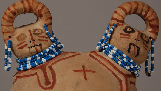 The meaning of the double-headed effigy vessel is unknown.  The two faces are facing forward, side by side in this vessel; however, sometimes faces are back to back.  The loop over the head is probably a decorative headdress, not a handle.  The two faces feature the same facial tattoos and beaded earrings and necklaces.  The main body design is typical of designs on these vessels but their meaning is unknown.  The plus signs have been interpreted as stars.  Annie Fields was a member of the Colorado River Indian Tribes who lived near Needles.  She apparently made the majority of her pottery in the 1950s and worked for only a decade or so.  She made male and female figures, children in cradleboards, animals, and effigy vessels.  Condition:  this effigy vessel is in remarkable condition.  Provenance: from the collection of Katherine H. Rust  Recommended Reading:  Mojave Pottery, Mojave People: The Dillingham Collection of Mojave Ceramics by Jill Furst. 