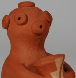 Alma is an award-winning pottery figurine artist. She learned from her mother, Carrie Reid Loretto, a respected pottery artist. In 1979, Alma participated in the landmark exhibition, “One Space: Three Visions,” at the Albuquerque Museum. Three years later, in 1982, she was featured in National Geographic Magazine. In the 1980s, she was married and lived for a while at Taos Pueblo, where she made pottery using the local materials. Her style could be characterized as “minimalist,” meaning that she has reduced the features of the human form down to minimal shapes. This Mudhead Katsina is featured in the style of the popular Rain God figurines, that is, holding a jug to collect rain water.  The figurine is slipped in rust-colored clay with only the slightest design on the jug.  The figurine is signed Alma L. Concha on the underside, a signature used during her time at Taos Pueblo.  She now signs her pottery Alma. Condition: original condition except for some stain on the underside where tape was removed. Provenance:  from the Katherine H. Rust collection Recommended Reading:  Southern Pueblo Pottery 2,000 Artist Biographies by Gregory Schaaf 