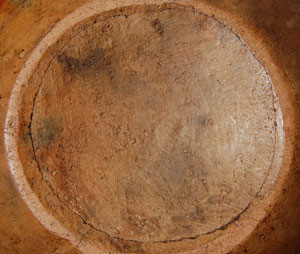 This turn-of-the-century olla from Cochiti Pueblo immediately captures the eyes of the viewer.  It is stunningly beautiful in its simplicity of design and marvelous patina.  For a jar over 100 years of age, it is remarkably in wonderful condition.  The bulbous body and graceful neck feature two design patterns.  The body is decorated with cloud elements in an X pattern and the neck has black triangles in alternating positions.  The rag-wiped Cochiti slip has assumed a beautiful warm patina from decades of personal handling, yet the design pattern is still relatively complete with only minor abrasion to some of the black paint.  Double framing lines with ceremonial line breaks are just below the black rim which also has a ceremonial break.  Another pair of framing lines just below the shoulder and at the bottom of the body design partially display ceremonial line breaks.  A wide red band of wiped-on red clay encircles the body of the vessel underneath the body design.  Condition:  the concave bottom has a crack encircling it but it does not appear to be of significance.  It could be stabilized if the purchaser desired it to be done.  Provenance: from a Santa Fe resident  Recommended Reading: A River Apart: The Pottery of Cochiti & Santo Domingo Pueblos by Valerie Verzuh, et al 