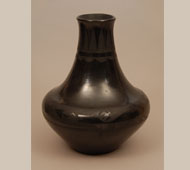 Maria Martinez was a very talented potter.  She had the creativeness to devise numerous vessel shapes and each was visually superior to the shapes of others.  This tall-neck jar is a good example.  The lower body is large and visually provides a stable base to the tall slender tapering neck.  This style neck on a body of lesser volume would not be as pleasing—a fact Maria understood.   This jar is signed Marie, which would place its date in the 1920s and would indicate that it was decorated by Julian.  The neck design is a series of clouds and an Avanyu encircles the widest area of the body, designs that fit the shape of the vessel beautifully.   Condition: structurally in excellent condition.  There are some slip cracks but they appear only to be slip cracks and they do not penetrate the clay body.    Provenance: from the collection of a Santa Fe family   Recommended Reading:  The Legacy of Maria Poveka Martinez by Richard Spivey