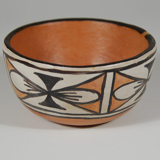 We originally purchased this small bowl in 2005 from Dominguita Aguilar, a Santo Domingo resident with whom we have been friends for a long time.  She told us that this was made by Peringrina Aguilar, her mother.   I have not been able to find any published reference to this potter, so I do not know what period she worked.  The bowl is signed with the initials P.A.N. and S.D.P. (Santo Domingo Pueblo) and a corn stalk image.