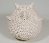 This is a very traditional white corrugated owl figurine that was built up from coils of clay left in roll form, not smoothed out. The rows were then impressed with a stick or other tool to achieve the design. This is similar to prehistoric utilitarian wares in which the rows of coils of clay were left visible.   Shutiva spent most of her career making pottery in the fashion of pre-historic corrugated utilitarian wares, a style revived by her mother, Jessie Garcia. She said she admired her mother's corrugated pottery so much that she vowed she would learn how to make it herself. It took her four years to master the technique, but master it she did.   Jessie Garcia, Shutiva's mother, is given credit for reviving the ancient art of corrugated pottery, but instead of the earth-colored clay generally used for the prehistoric corrugated wares; she chose to use the white, un-slipped Acoma clay, thus marrying the style of the old ways with a look of the new.   Shutiva brought her mother's creation to fruition and spent her career almost exclusively devoted to making white corrugated wares. Adding painted designs to small portions of her pottery was an addition late in her career as was the addition of animal and reptile forms in bas-relief.   This owl figurine was probably made in the 1980s. The corrugated rows of clay are continuous from the bottom of the vessel to the top. There is no flattened bottom to the vessel. The artisan's name is painted on the underside.   Condition:  appears to be in original condition but perhaps with a little more dust. Recommended Reading:  Southern Pueblo Pottery 2,000 Artist Biographies by Gregory Schaaf