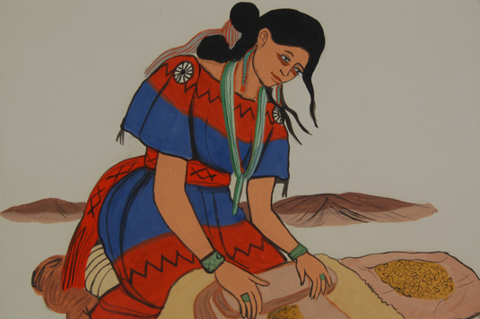 close up view of woman, dressed in her finest, grinding corn on a metate using a mano