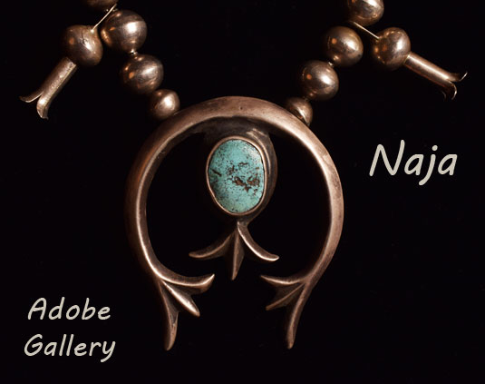 The naja is cast silver and has a sweeping curve with ends reaching out into a three-pronged spread.  Suspended from the top of the naja is a large oval sky blue turquoise cabochon with a dark matrix.  It is anchored in a silver bezel and repeats the three-pronged spread.  