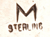 Artist hallmark signature of Eugene Mitchell, Diné Silversmith