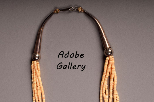 This six-strand coral and heishi necklace was most likely created by a Diné artist.  Were it held in place by a “pueblo wrap”, we’d attribute it to a Kewa artist, but the silverwork used here suggests Diné origin.