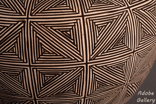 Close up view off a section of this fine line pottery jar.