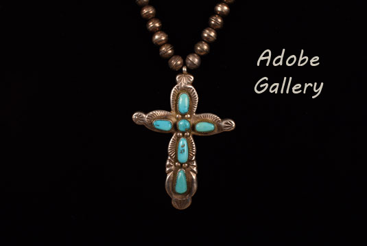 Close up view of the turquoise cross and silver beads.