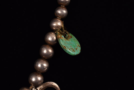 A flat beautiful polished turquoise disc was tied onto the beads