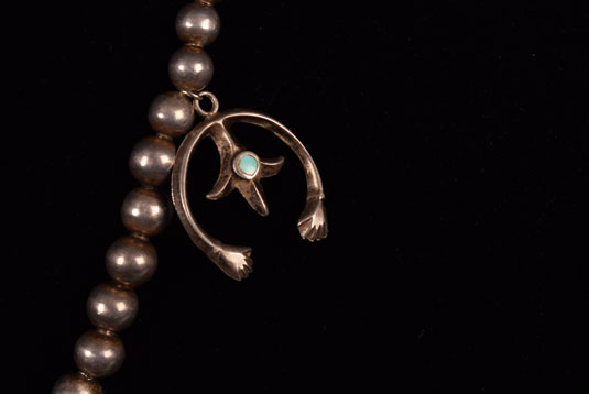 A smaller silver naja with open hands and a fleur-de-lis with a small turquoise cab was added