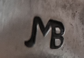 Artist signature initials of Johnny Mike Begay, Diné Silversmith