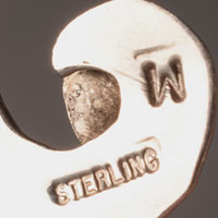 A marking of the letter W appears, along with Sterling, on the necklace and one earring, however we have been unable to identify the artist by that single initial.