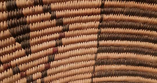 At first glance, one does not recognize that this Apache basket has some red included in the design. The amount of red the weaver chose to include is minimal, as if she wished to hide its use. She inserted red in the diamond patterns nearest the rim. If one counts down from the first row below the black rim, there is red in the triangles on rows 6, 8 and 10 on each of the triangles around the basket.