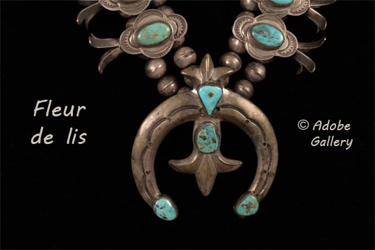 At the center of the necklace is a naja with four turquoise gemstones, one of which rests on the silver fleur de lis.