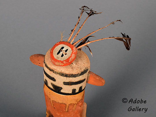 The disc on his head traditionally holds a ring of eagle feathers.