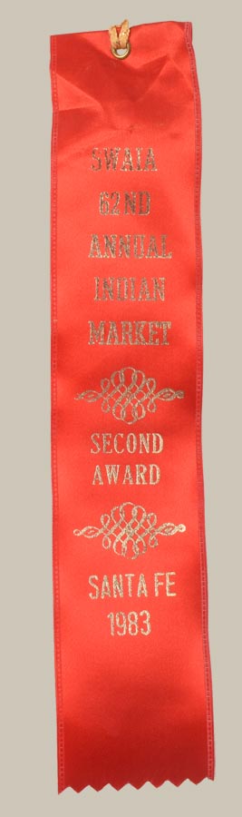 The painting is signed and dated 1983 and includes a ribbon from the SWAIA 62nd Annual Indian Market, where Montoya earned a second-place award that same year. This piece reflects Montoya’s mature period, during which he was deeply engaged in fusing Indigenous subject matter with contemporary artistic strategies.
