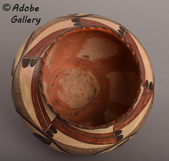 In this jar, the interior motif is not a band but a clearly pedaled flower form. Whether it began as a decorative gesture or a spontaneous act of expression is uncertain. What is clear is that this jar holds a quiet visual secret that adds to its mystery and charm, and makes it a standout piece among historic Acoma pottery.