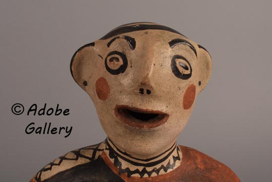 Close up view of the face of this pottery figurine.