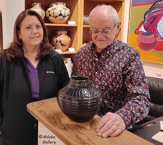 Artist Linda Tafoya Sanchez of Santa Clara Pueblo poses with one of her latest pottery creations with Alexander Anthony of Adobe Gallery.